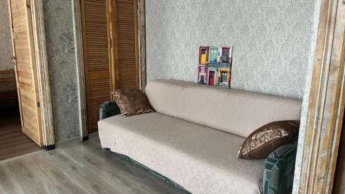 een witte bank in een woonkamer met een spiegel bij Imantas in Daugavpils