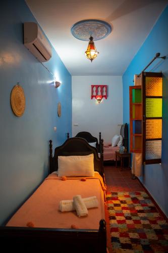 a bedroom with a bed with two towels on it at Riad Misk Fez in Fès