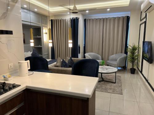 a kitchen and living room with a couch and a table at Penta Square Signature Apartments DHA Phase 5 Lahore in Lahore