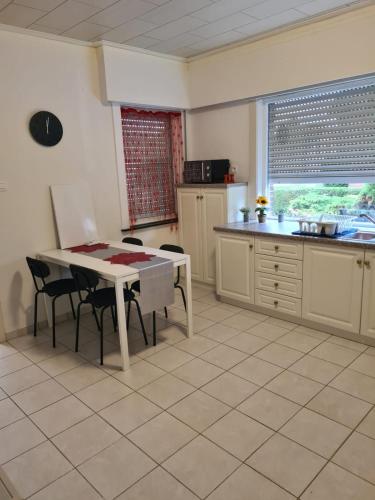 a kitchen with a table and chairs and a table and a counter at Bianca's vakantiehuis in Houthalen-Helchteren