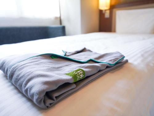 a blanket laying on a bed in a room at ibis Styles Kyoto Shijo in Kyoto