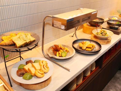 a buffet with plates of food on a shelf at ibis Styles Kyoto Shijo in Kyoto
