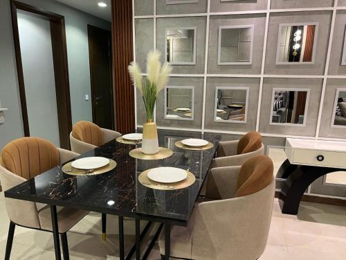 a dining room with a table and chairs and a piano at Penta Square Signature Apartments DHA Phase 5 Lahore in Lahore