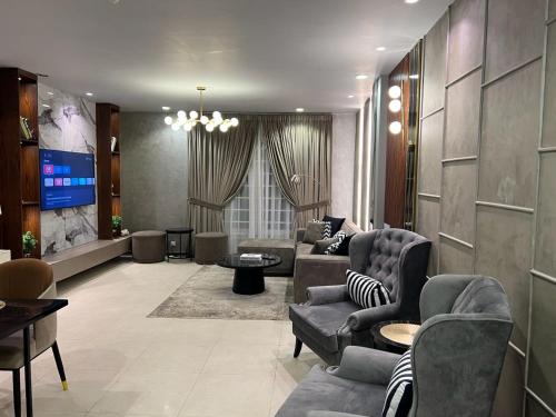 a living room with couches and a flat screen tv at Penta Square Signature Apartments DHA Phase 5 Lahore in Lahore