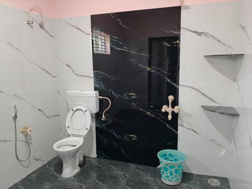 a bathroom with a white toilet and a shower at Siruvani Farm Stay Near Isha Yoga Adiyogi in Alāndurai