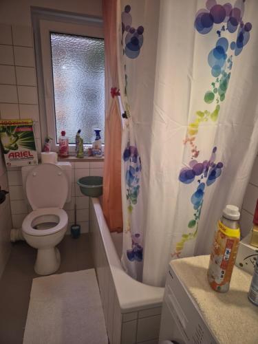 ミュンヘンにあるZimmerのトイレとシャワーカーテン付きのバスルーム