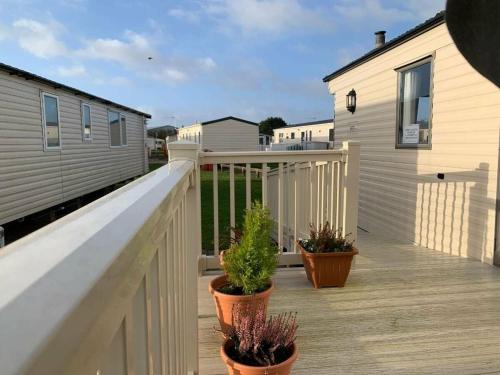 a deck with potted plants on a house at Cala Gran Holiday Park - Holiday Accommodation 10830 in Fleetwood