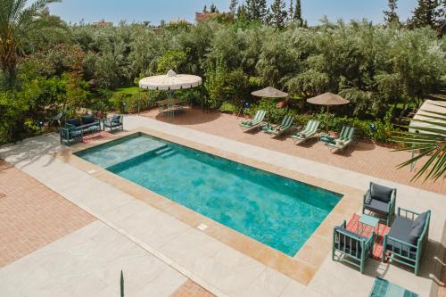 an overhead view of a swimming pool with chairs and umbrellas at Dar Salah - Eddine Oasis Pool & SPA in Oulad Mazoug