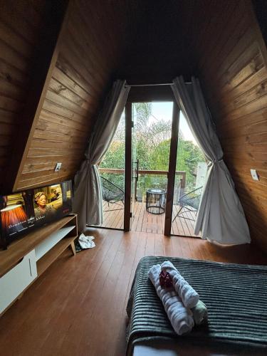 Habitación con cama y puerta de cristal grande. en Chalés SKYCHALES, en Governador Valadares