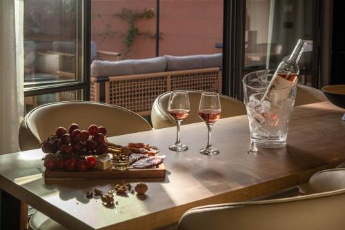 a table with two glasses of wine and a plate of food at Arcasa Villas Collection by Omilos Hotels in Archanes