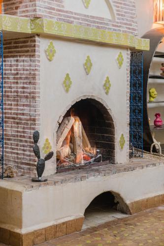 a brick oven with a fire in it at Dar Salah - Eddine Oasis Pool & SPA in Oulad Mazoug
