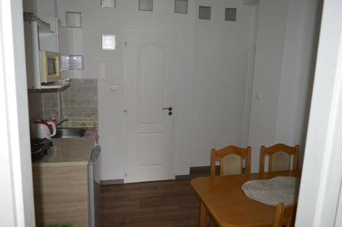 a kitchen with a table and a white door at Apartmány KARINA in Veľký Meder