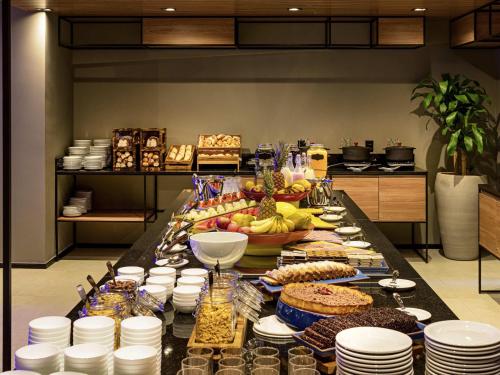 a buffet of food on a table in a kitchen at Ibis Balneario Camboriu in Balneário Camboriú