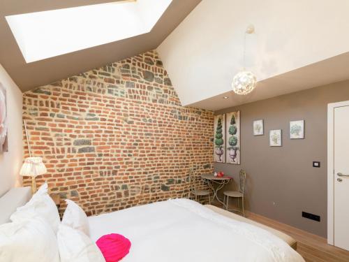 a bedroom with a brick wall and a bed at Marche Farmhouse with Hot Tub in Marche-en-Famenne