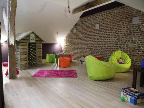 a room with green and orange chairs and a brick wall at Marche Farmhouse with Hot Tub in Marche-en-Famenne