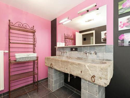 a bathroom with a large sink and pink walls at Marche Farmhouse with Hot Tub in Marche-en-Famenne