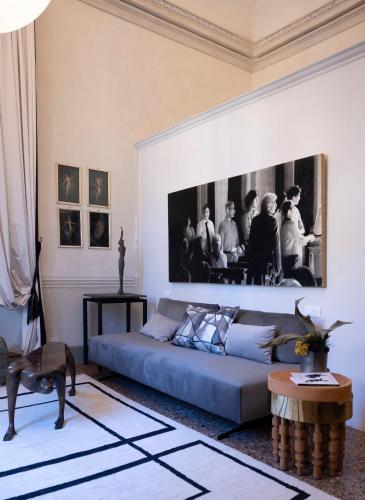 a living room with a couch and a picture on the wall at Palazzo Giacometti Suites in Piacenza