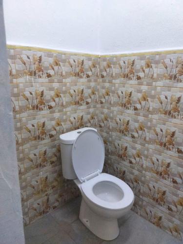 a bathroom with a toilet with a duck pattern on the wall at Roomstay Ummi in Machang