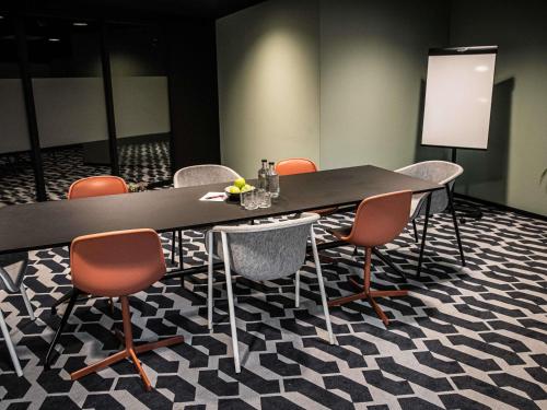 a meeting room with a long table and chairs at Hotel Valkenburg by Mercure - Next to Shimano Experience Center in Valkenburg
