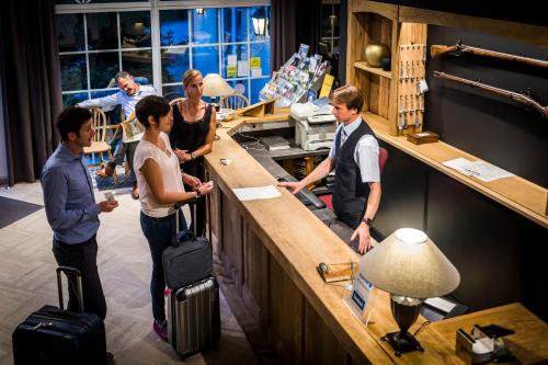 un grupo de personas de pie en un mostrador con equipaje en Hotel In den Bonten Os, en Rijmenam