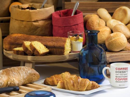 a table with bread and croissants and a blue bottle at Ibis Budget Paris porte de la Chapelle - Aréna in Paris