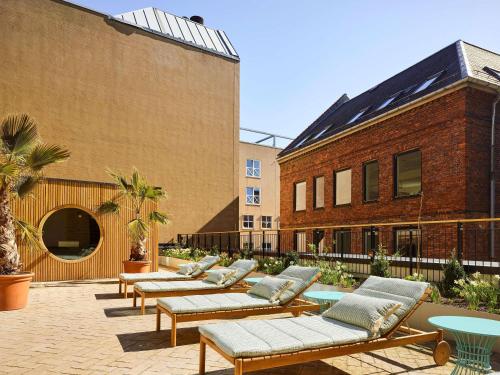 a row of benches in a courtyard next to a building at 25hours Hotel Indre By in Copenhagen