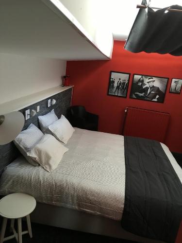 a bedroom with a bed and a red wall at Le Grand Cabaret in Nieuwpoort