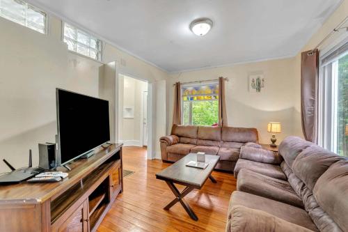 a living room with a couch and a flat screen tv at The Hill All Star Baseball Rentals in Oneonta