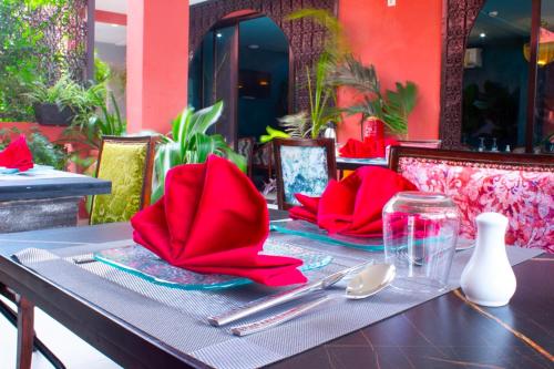 a table with red napkins and utensils on it at Hôtel La Villa Racine in Dakar