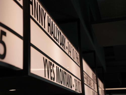 a group of street signs hanging from a building at ibis Styles Lens Centre Gare in Lens