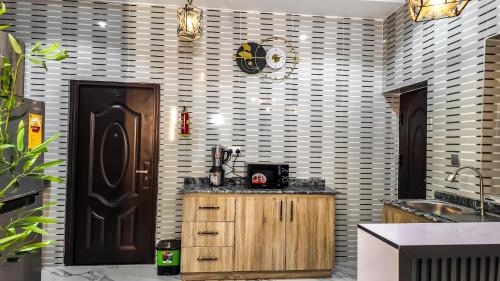 a kitchen with a wooden cabinet and a black door at Jayhaven Crystal Serviced Apartment in Uyo
