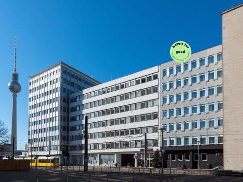um grande edifício com um relógio em cima em greet Berlin Alexanderplatz em Berlim