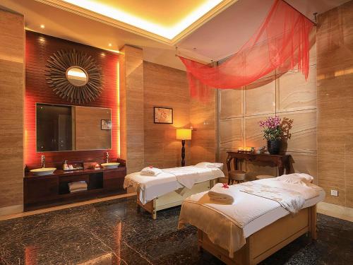 a hotel room with two beds and a television at Pullman Haikou in Haikou