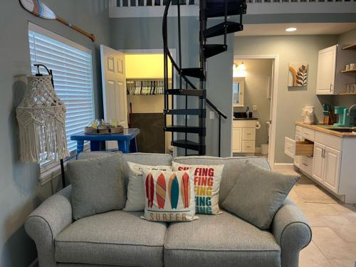 a living room with a gray couch with pillows at Paradiso dei Limoni in Chicken Island