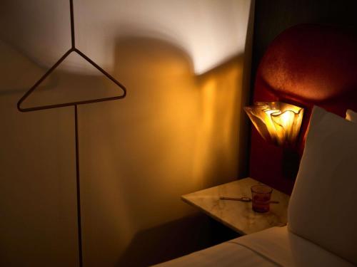 a bedroom with a bed and a table with a lamp at Hotel Morris Sydney, Handwritten Collection in Sydney