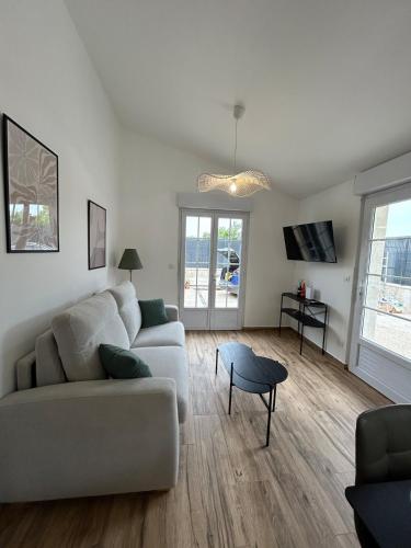 a living room with a couch and a table at Les gites saint Laurent - l'élégante in Mouy