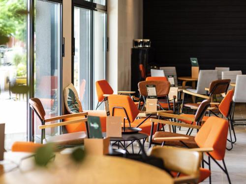 an empty classroom with orange chairs and tables at ibis Lyon Sud Oullins in Oullins
