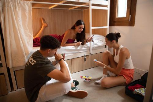 a group of people sitting on the floor in a room at Urban Hostel Palma - Albergue Juvenil - Youth Hostel in Palma de Mallorca