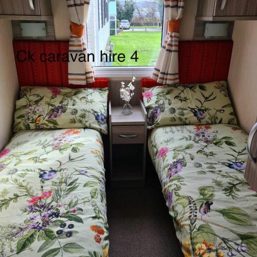 two beds in a small room with a desk at Whitehouse Leisure Park - Holiday Accommodation 19057 in Kinmel Bay