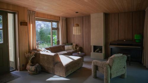 a living room with a couch and a fireplace at Luxe boshuis met Spa in Otterlo