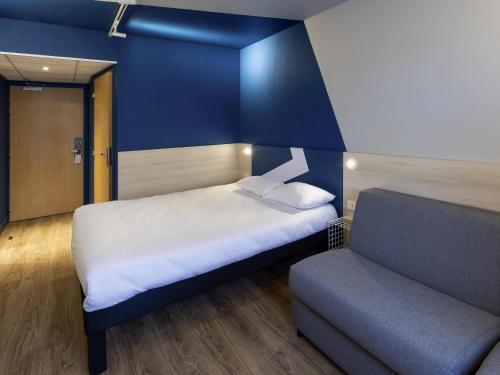 a small room with a bed and a couch at ibis Budget Millau Viaduc in Millau