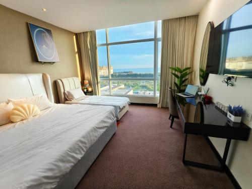 a hotel room with two beds and a large window at Hatten Hotel Super Sea View 4pax Mid Floor in Melaka
