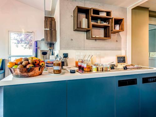 a kitchen with a bowl of fruit on a counter at Greet Hotel Bordeaux Floirac Arena in Floirac