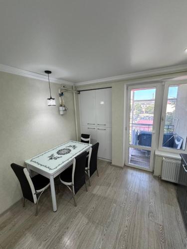 a dining room with a white table and chairs at Panorama view apartament tolstoi str in Chişinău