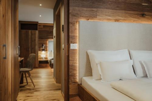 a bedroom with a bed with white pillows at Hotel B&B Feldmessner in Brunico