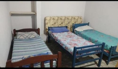 a room with three beds in a room at El Carau Alquileres in Paso de la Patria