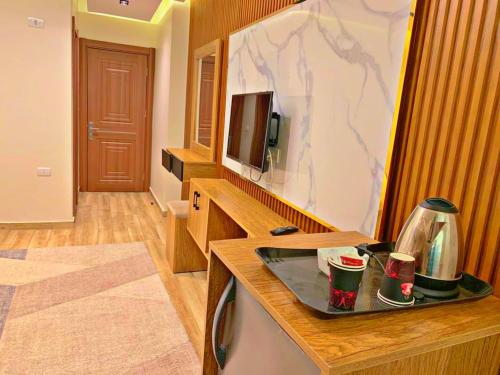 una habitación con un televisor y una mesa con tazas en Roone pyramids view hotel, en El Cairo