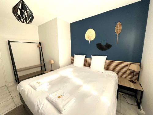 a bedroom with a large white bed with a blue wall at La Loupiote - Jacuzzi compris SANS supplément ! in Lupcourt