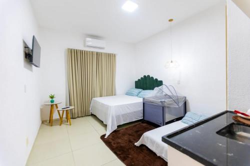 a room with two beds and a sink in it at Pousada Boutique Três Marias in Guarujá