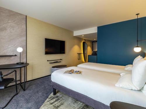 a hotel room with a large bed and a tv at Novotel Liverpool Paddington Village in Liverpool